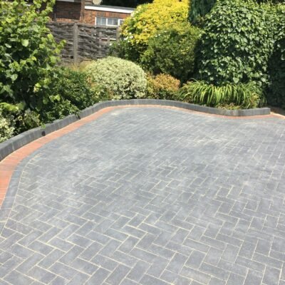 Curved block paving driveway with decorative edge installed by MUHAJ in Greater London residential garden