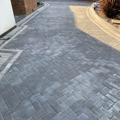Curved edge block paving driveway with light and dark contrast finish by MUHAJ in Hertfordshire