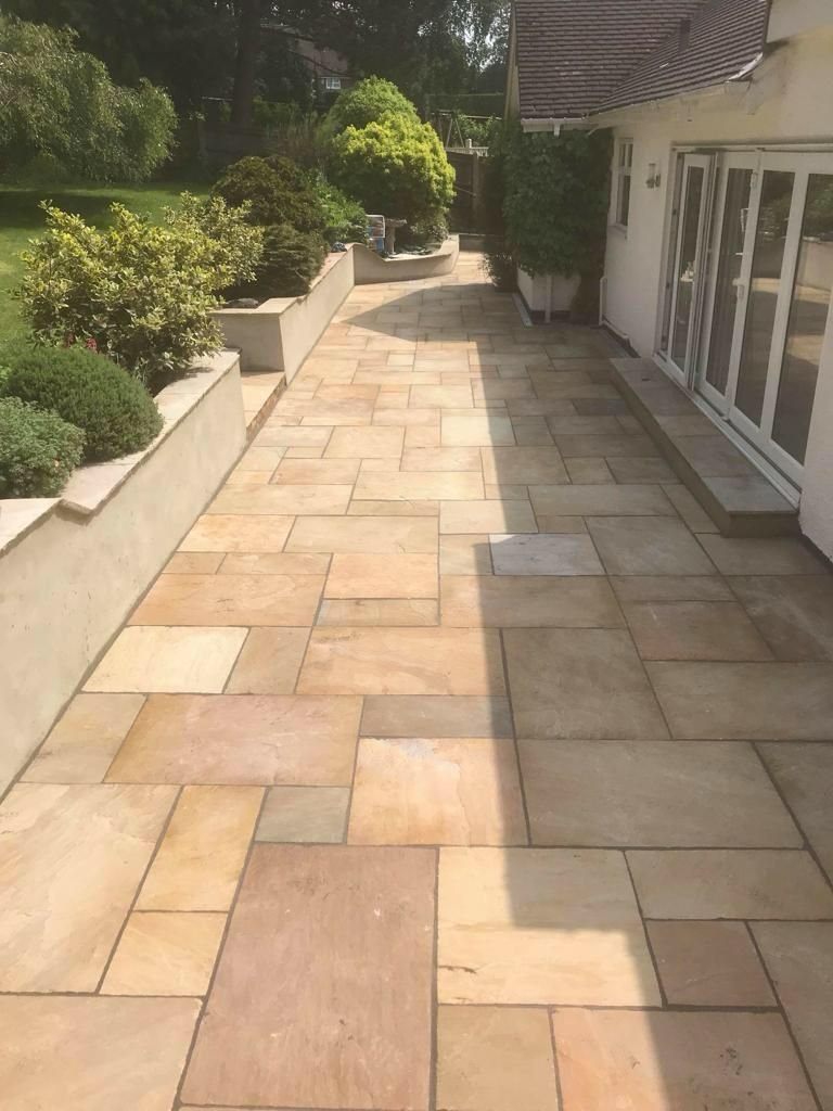 Natural stone patio paving installed by MUHAJ for a modern garden in North London