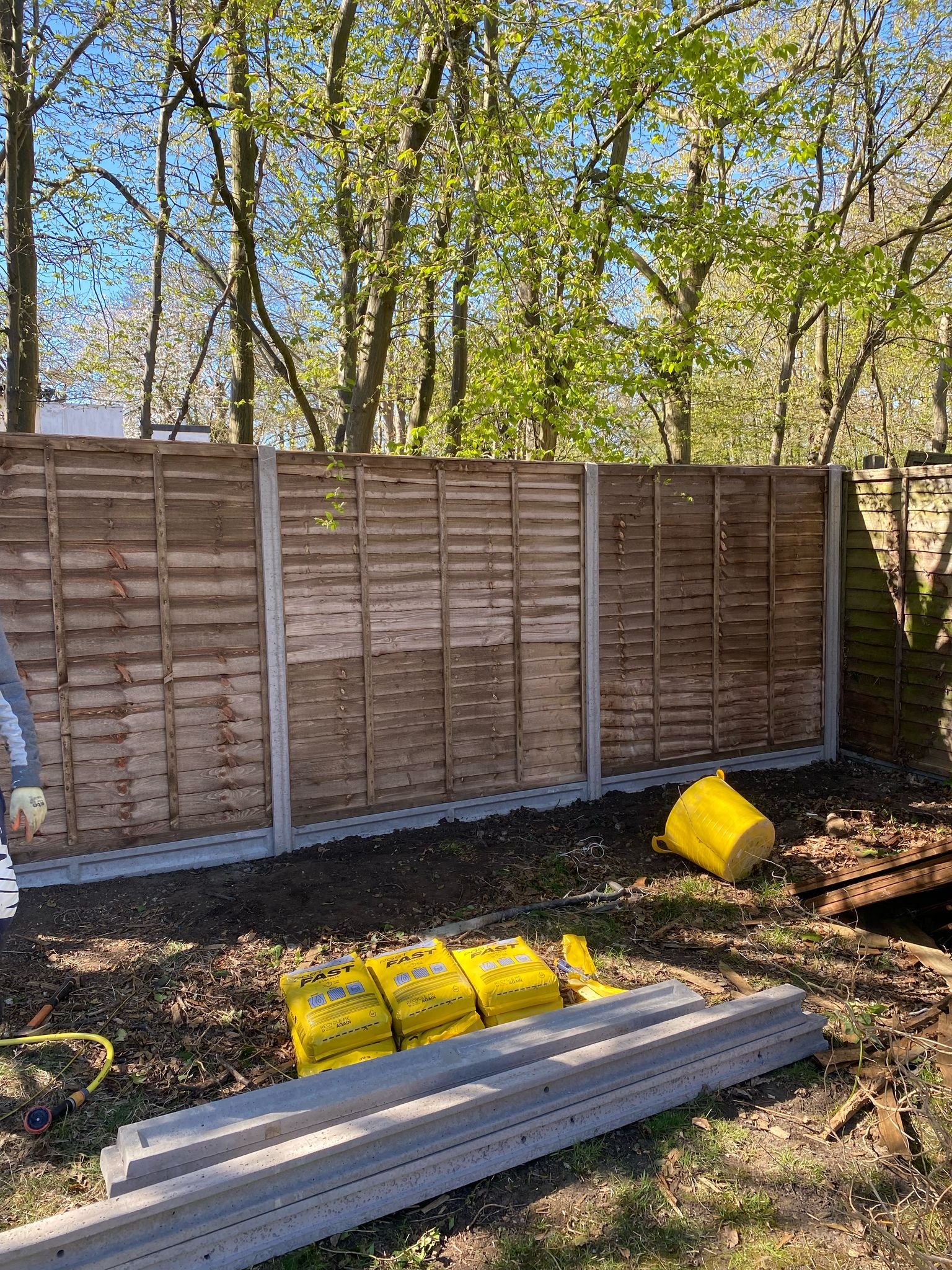 Timber panel fencing with concrete posts during installation by MUHAJ in garden project in North West London