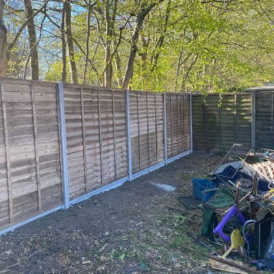 Extended timber panel fencing with concrete posts installed by MUHAJ for woodland property boundary in Edgware