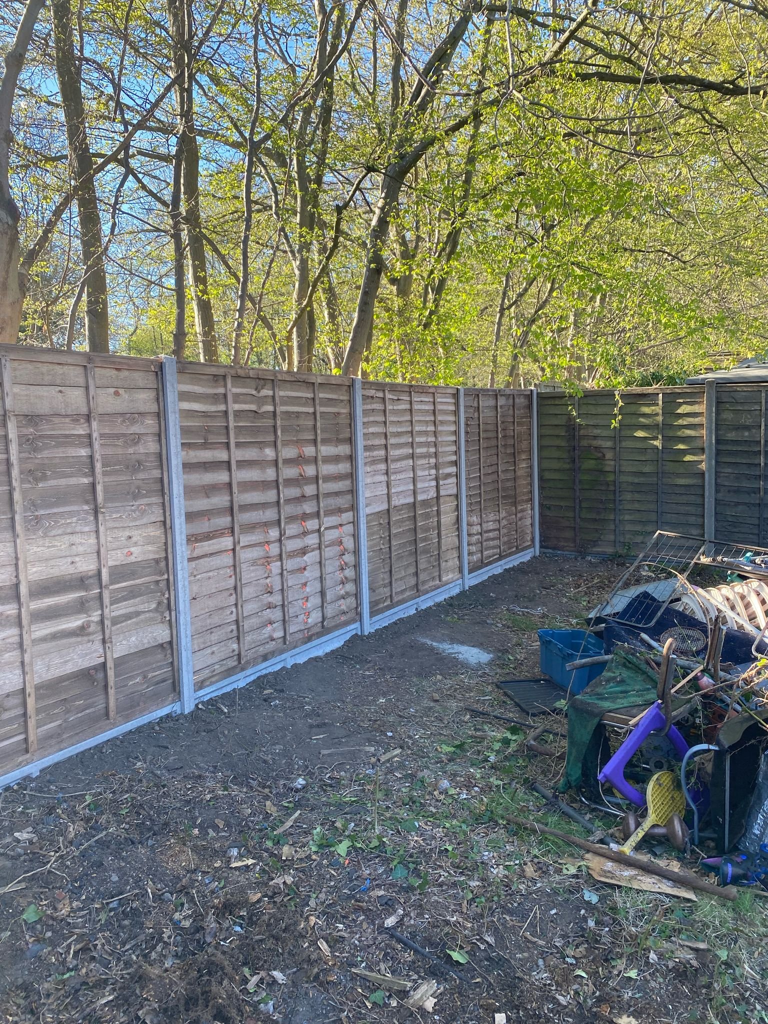 Extended timber panel fencing with concrete posts installed by MUHAJ for woodland property boundary in Edgware
